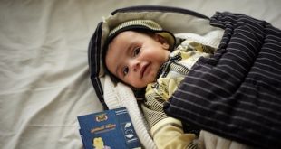 Baby_with_completed_vaccine_card_(9295966469)