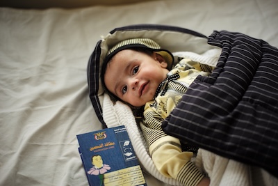 Baby_with_completed_vaccine_card_(9295966469)